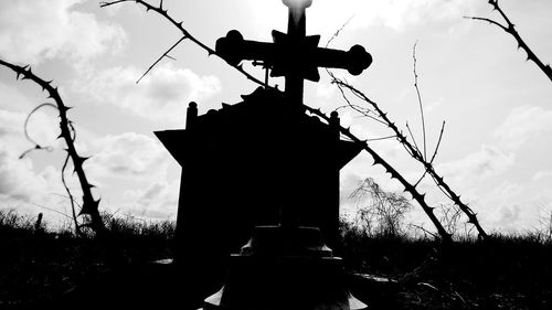 Low angle view of silhouette statue against sky