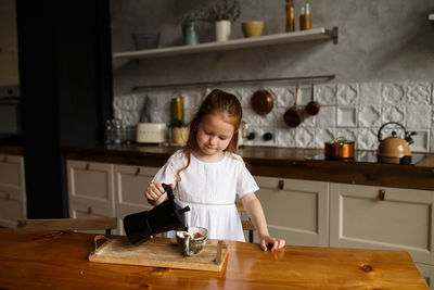 Cute girl preparing food in kitchen