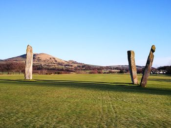 Built structure on landscape against clear blue sky