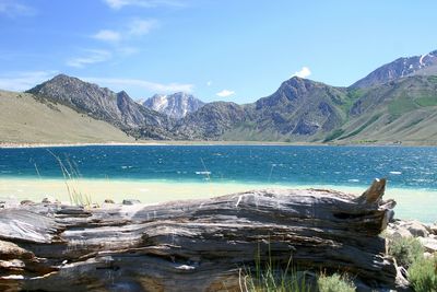 Scenic view of lake and mountains against blue sky
