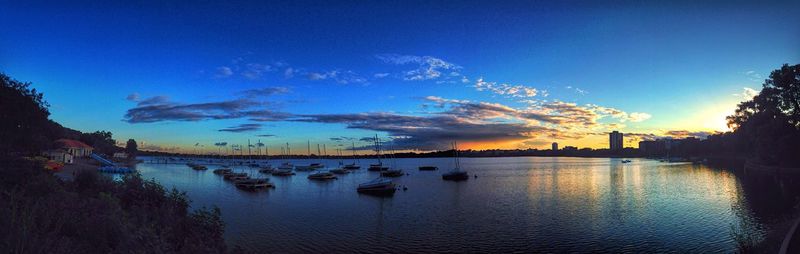 Boats in calm sea at sunset