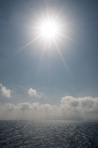 Scenic view of sea against bright sun