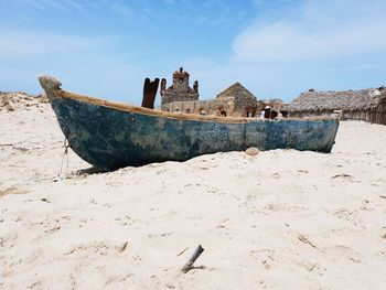 Abandoned ship on beach against sky