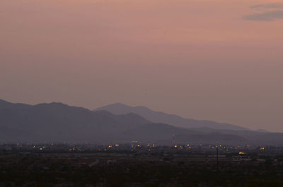 High angle view of illuminated city against sky at sunset