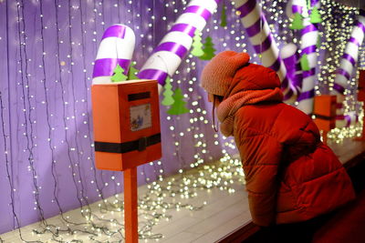 Rear view of man holding illuminated lighting equipment