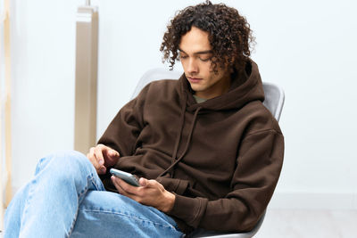 Young man surfing net sitting on sofa