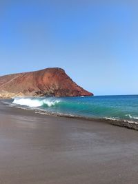 Scenic view of sea against clear blue sky