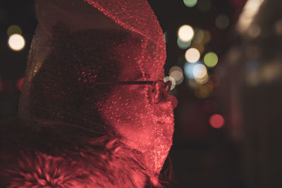 Close-up of woman covered with plastic bubble bag in darkroom