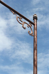 Low angle view of rusty pole against sky