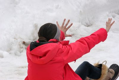 Girl with arms raised on snow covered field