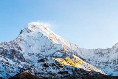 Scenic view of snowcapped mountains against clear blue sky