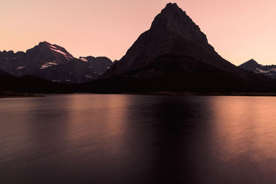 Scenic view of lake and mountains against sky during sunset