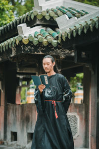 Portrait of young woman standing in city