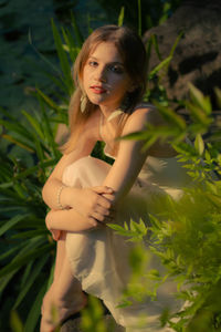 Portrait of smiling young woman sitting on field