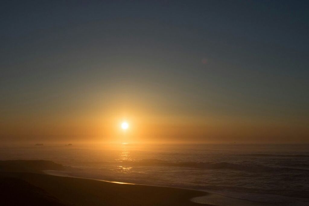 SCENIC VIEW OF BEACH AGAINST SKY AT SUNSET