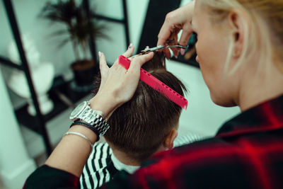 High angle view of woman cutting boy hair