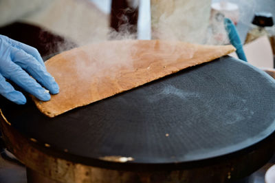 Close-up of person wearing glove preparing food