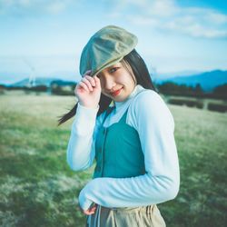 Portrait of smiling young woman standing on field