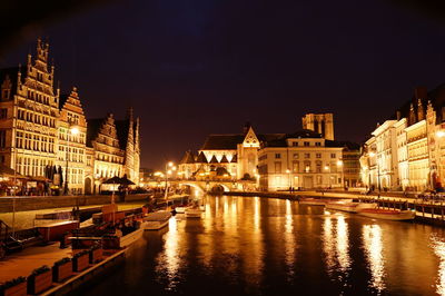 Illuminated buildings in city against clear sky at night