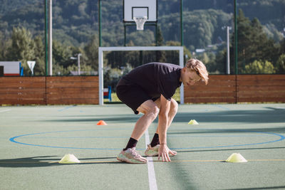Active hockey player is preparing for the outdoor season. blond athlete sprints between the cones