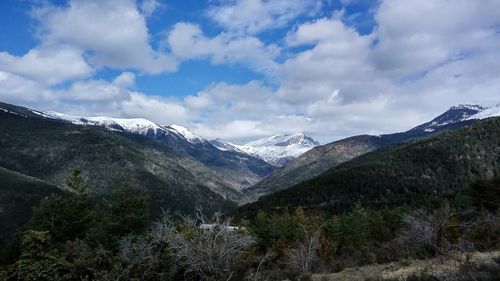 Scenic view of mountain range against cloudy sky