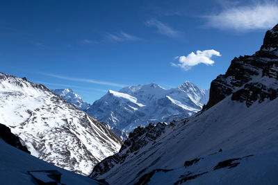 Scenic view of snowcapped mountains against blue sky