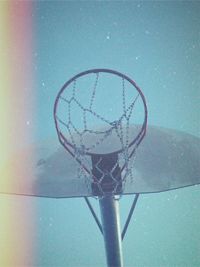 Close-up of basketball hoop against blue sky