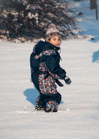 Portrait of boy walking on snow