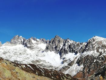 Scenic view of mountains against clear blue sky