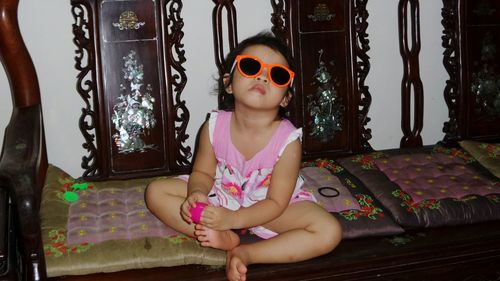 Girl wearing sunglasses sitting at home