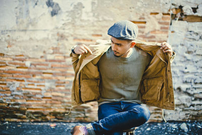 Portrait of man wearing hat against wall