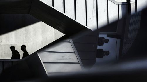Close-up of silhouette people standing on tiled floor