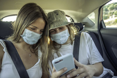 Woman using smart phone in car