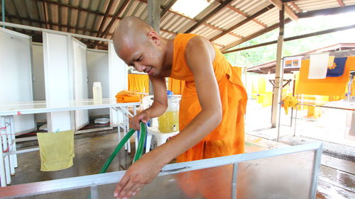 Monk cleaning equipment indoors