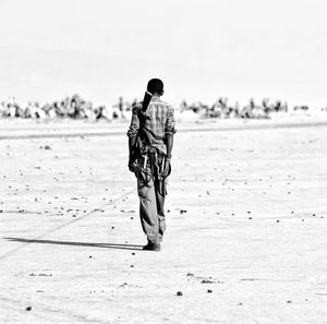 Rear view of man walking on beach