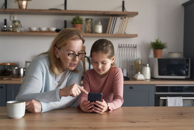 Grandmother and granddaughter talking on video call at home