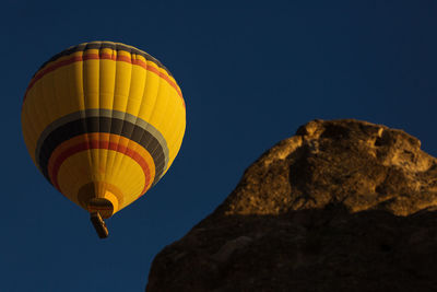 Low angle view of hot air balloon against clear blue sky