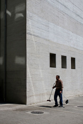 FULL LENGTH REAR VIEW OF MAN WALKING ON FOOTPATH