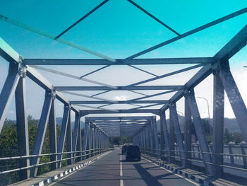 Cars on bridge against sky