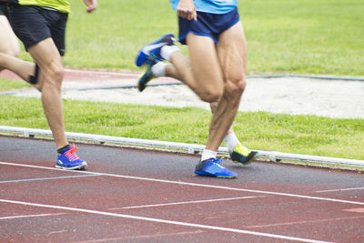 Low section of people running on grassland