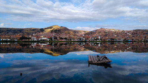 Scenic view of lake by buildings against sky