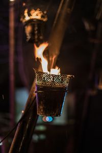 Close-up of hand holding burning candle