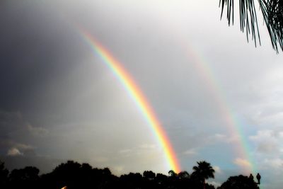 Low angle view of rainbow against cloudy sky