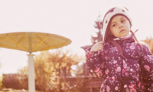Portrait of girl standing against clear sky