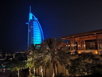 Low angle view of illuminated modern building against sky at night