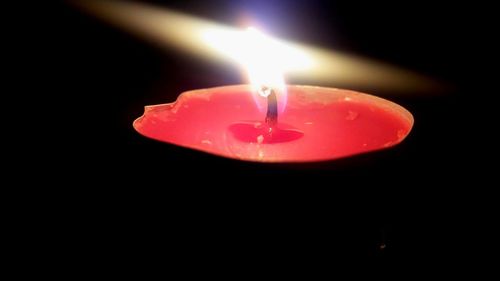 Close-up of lit candle in dark room