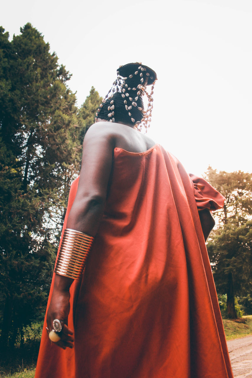 red, dress, one person, clothing, adult, fashion, gown, nature, women, spring, traditional clothing, costume, sky, day, female, tree, plant, standing, photo shoot, temple, outdoors, statue, rear view, young adult, three quarter length, religion
