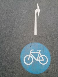 High angle view of arrow and bicycle signs on road