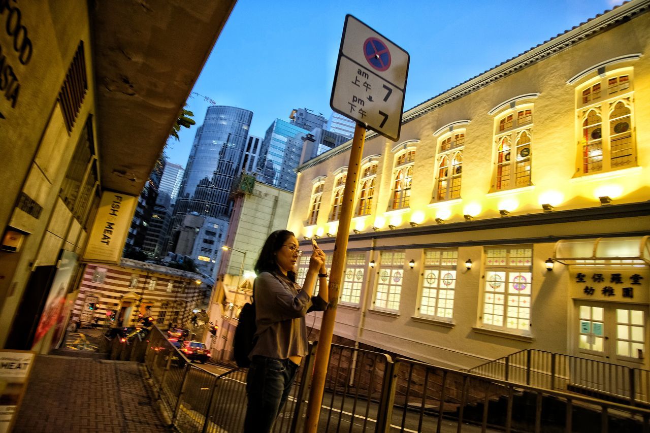 FULL LENGTH OF A MAN WALKING ON ILLUMINATED CITY