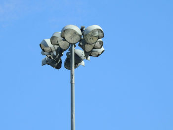 Low angle view of floodlight against clear blue sky